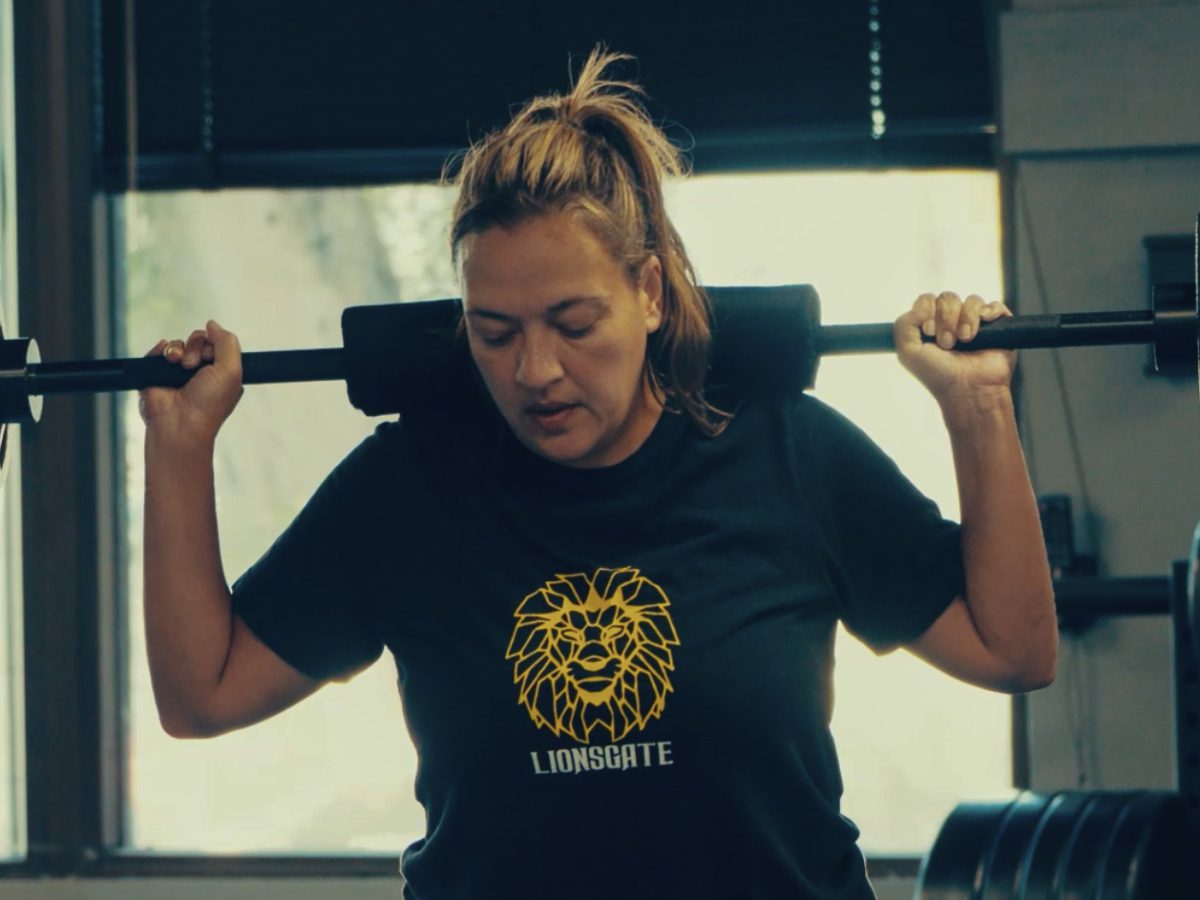 A woman squatting weights at DNA Fitness Club.